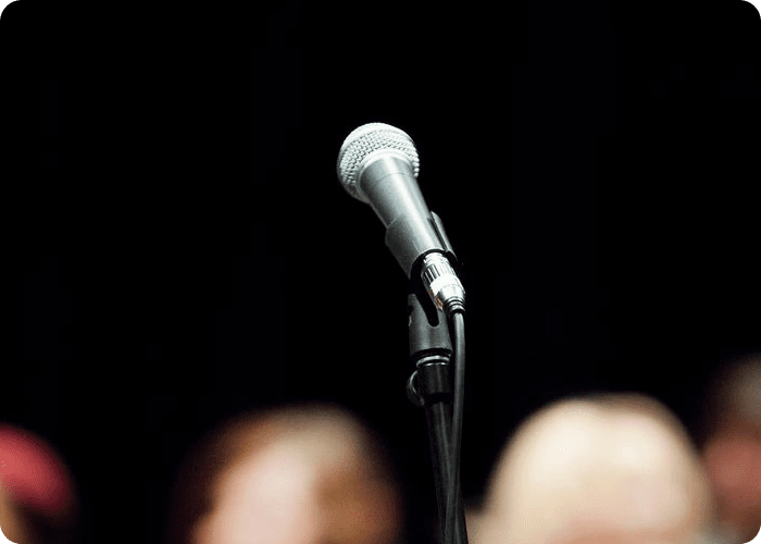 A microphone is on the stand in front of two people.