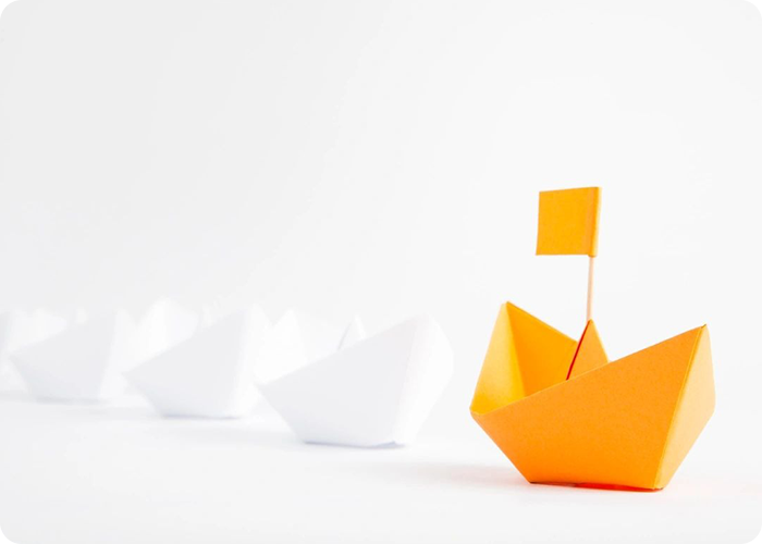 A row of paper boats with one boat in the middle.