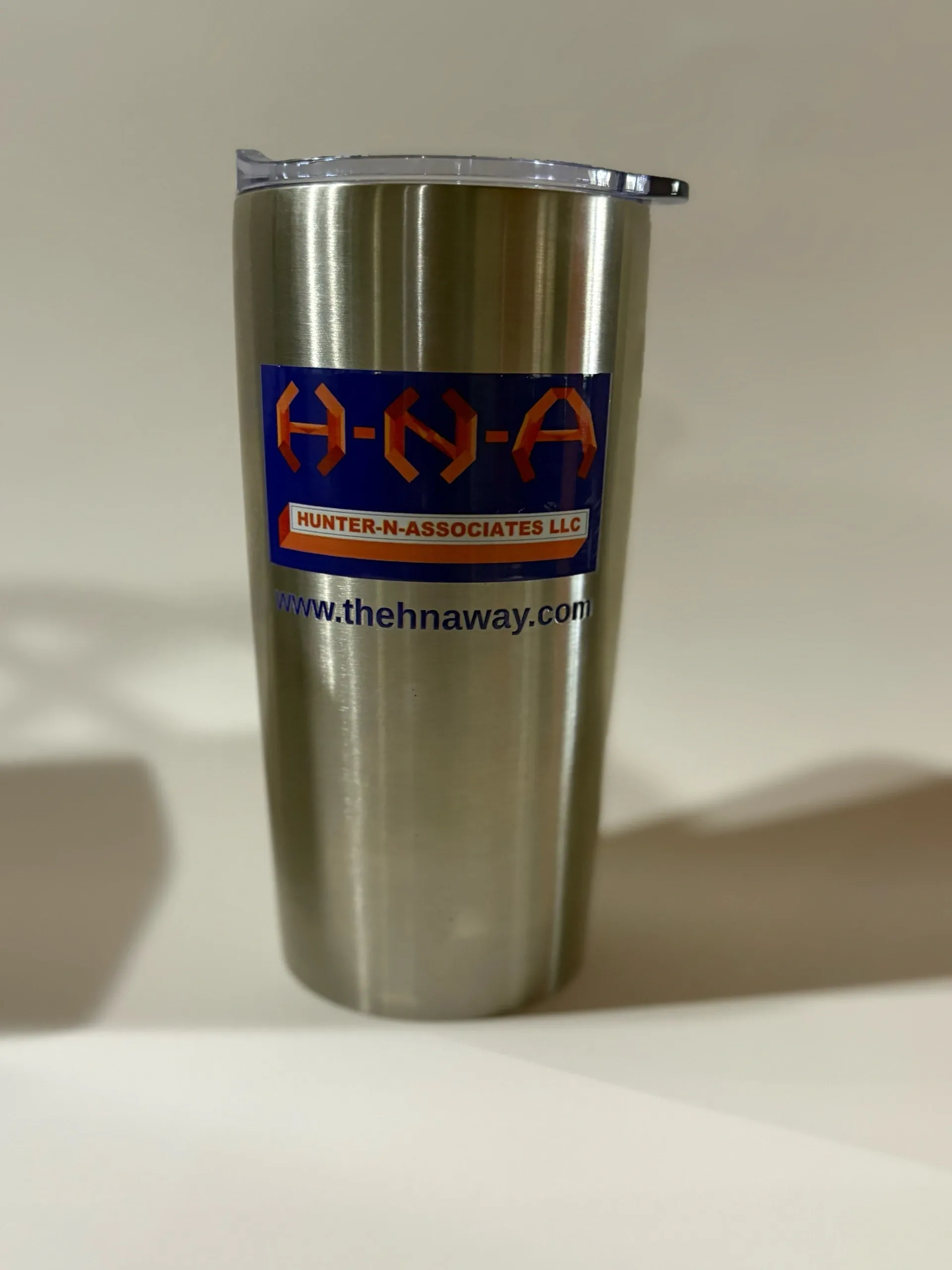 Stainless steel tumbler with H-N-A logo.