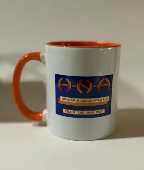 White mug with H-N-A logo design.